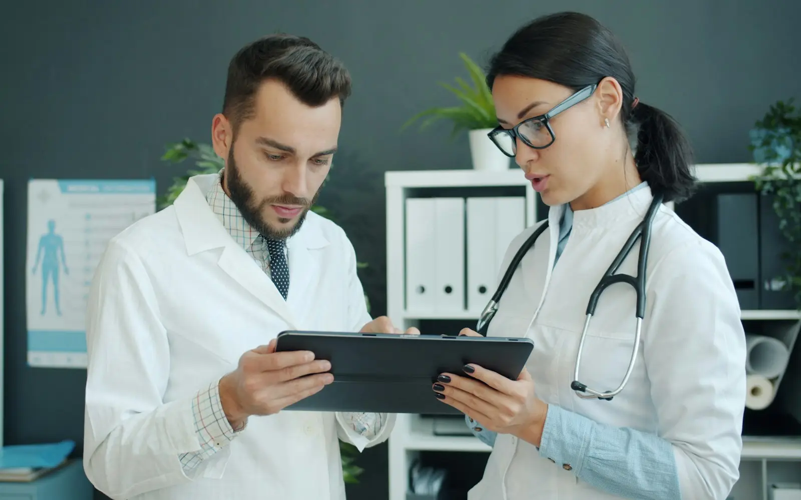 Two clinicians reviewing information together on a tablet in a clinic